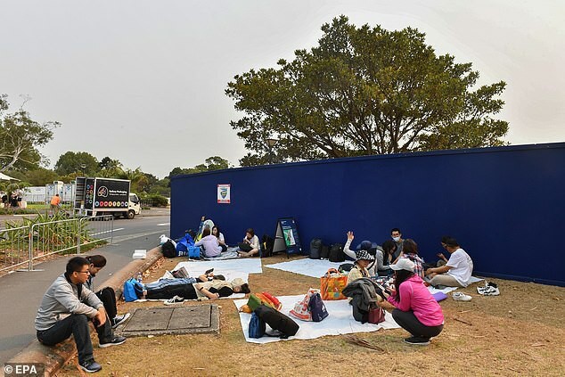 Du khách trải bật nằm nghỉ trong lúc chờ đợi. Ảnh: EPA: